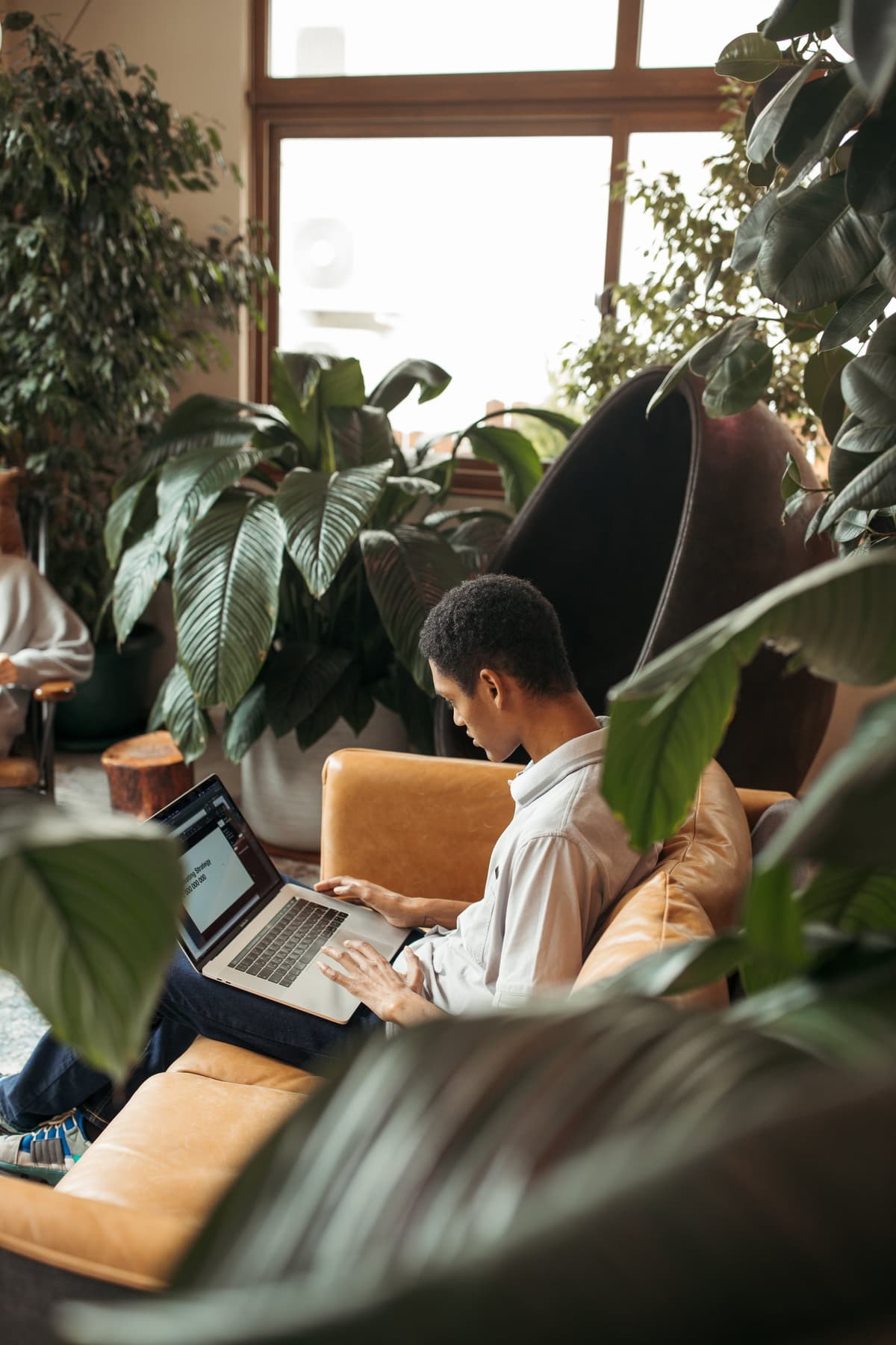 man on his laptop with leaves around